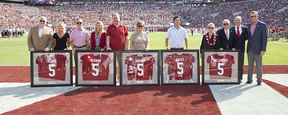 The Founders standing on the field with their jerseys