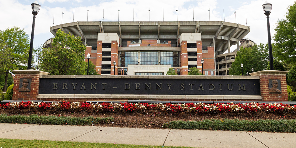Sign outside of Bryant-Denny Stadium with the stadium in the background