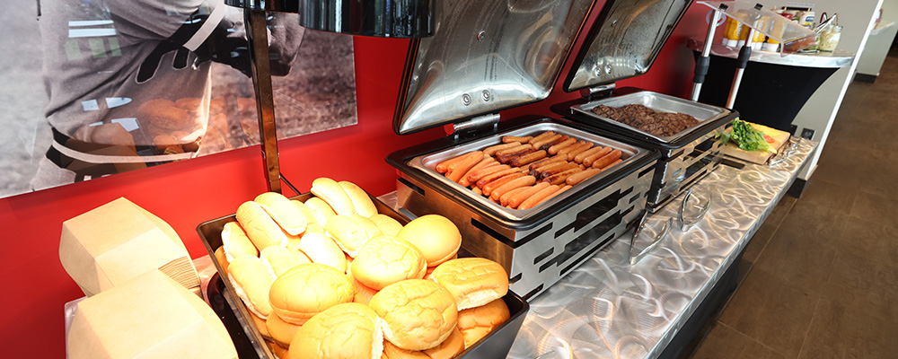 Hamburgers, hot dogs, and buns on a buffet table