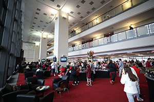 People milling about buffets with black chairs in conversation groupings