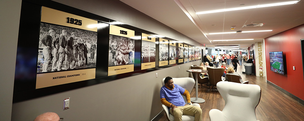 Large hallway with seating groups and artwork showcasing National Championships won